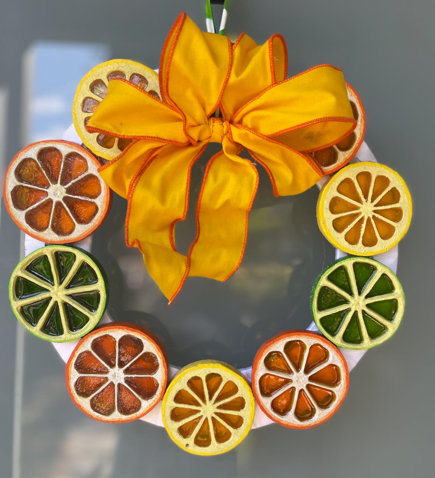 wreath made of orange, lemon and lime slices with an orange bow, product of Midnight Maker Wreaths