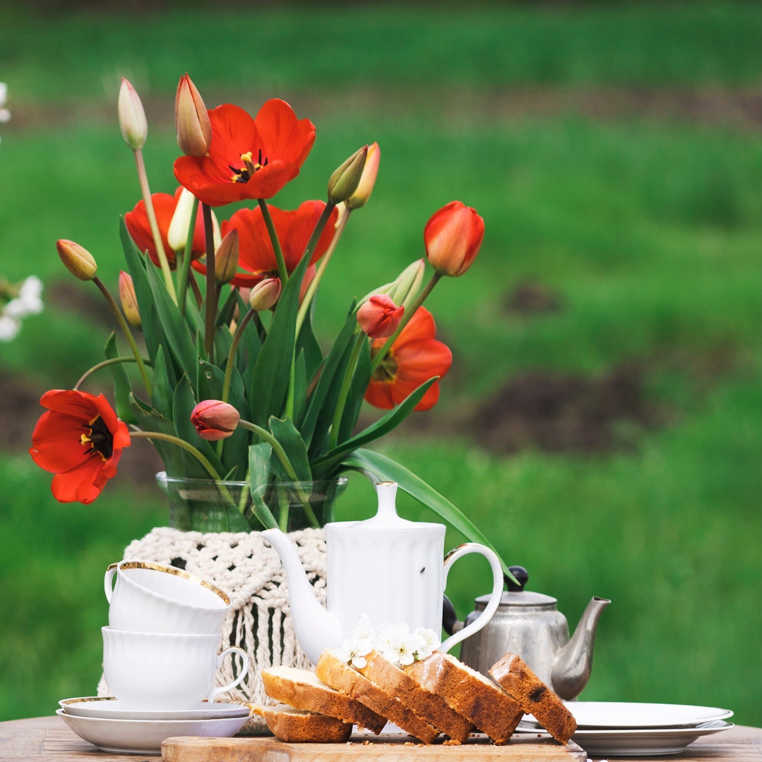 tea and cakes on a table with a vase of flowers